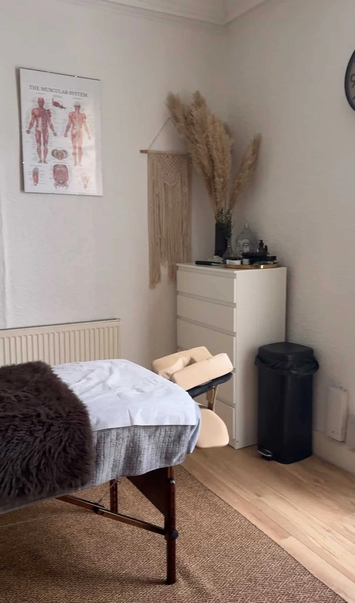 Treatment room at Roma Sports Therapy in Prescot, with anatomy charts and massage table